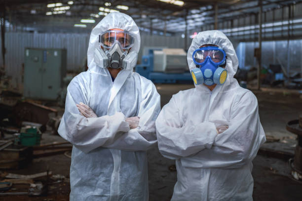 istock Two people in white protective gear are standing in front of a building 2168936754