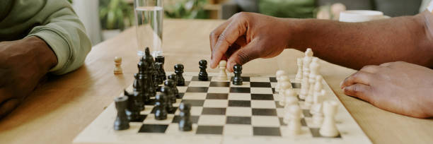 istock Unrecognizable Friends Playing Chess Game Round Website Banner 2168944126