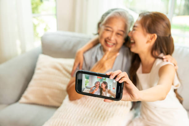 istock Asian family using smartphone taking selfie together. 2168946252