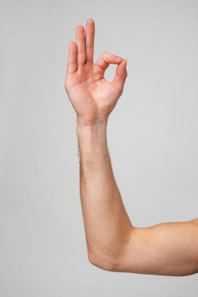 Mans Hand Showing Sign against gray background close up