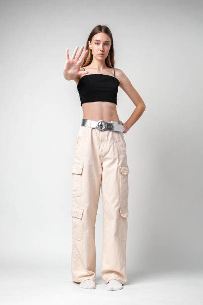istock Young Woman Holding Up Hand In Front Of Her In Studio Setting 2168948884