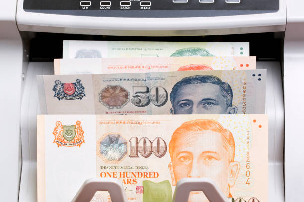 istock Singapore dollar in the counting machine 2168954919