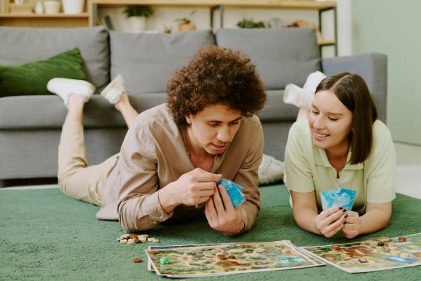 istock Couple Relaxing On Floor And Playing Board Game 2168961080
