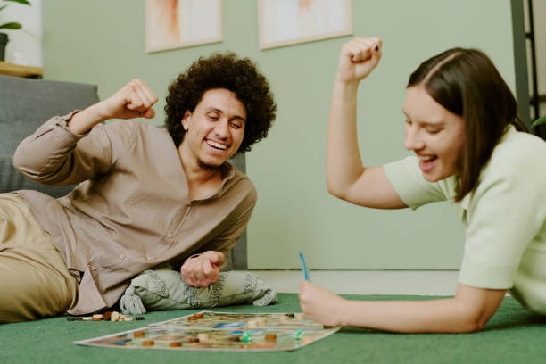 istock Joyful Couple Playing Board Game On Floor 2168961325