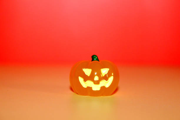 A captivating Halloween illustration showcasing pumpkins, a grim reaper, skulls, ghosts, and somber signs, all set against a moody red and Orange background.