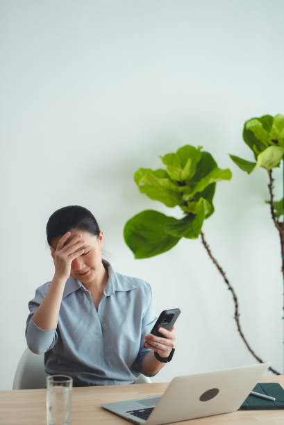 istock Asian woman using smartphone suffering from problem with work or financial. 2168962681