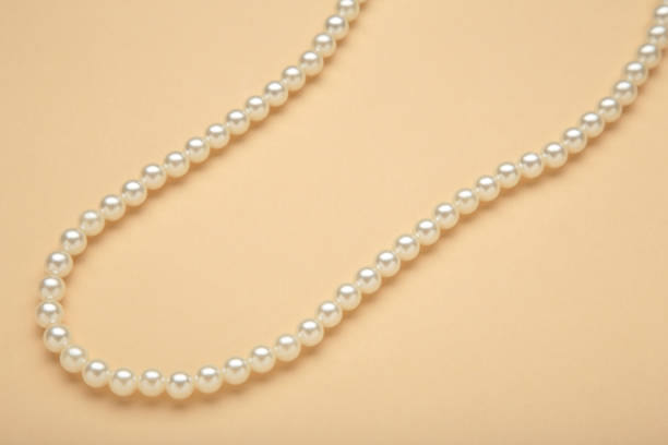 istock Elegant pearl necklace on beige background, top view. Space for text 2168964887