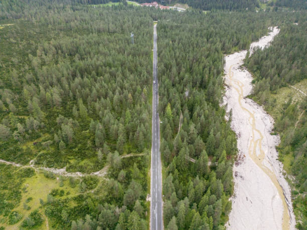 istock Straight Road Through Forested Valley with Nearby River 2168973027