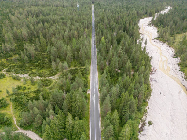 istock Straight Road Through Forested Valley with Nearby River 2168973251