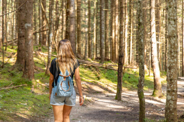 istock Woman Walking Along a Forest Path with Tall Trees 2168975568
