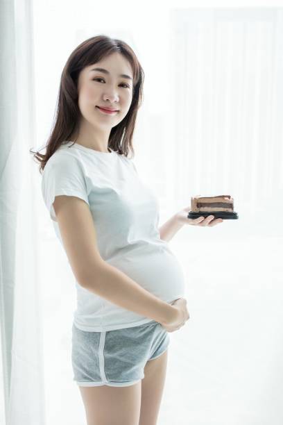 istock Pregnant woman eating cake 2168976192