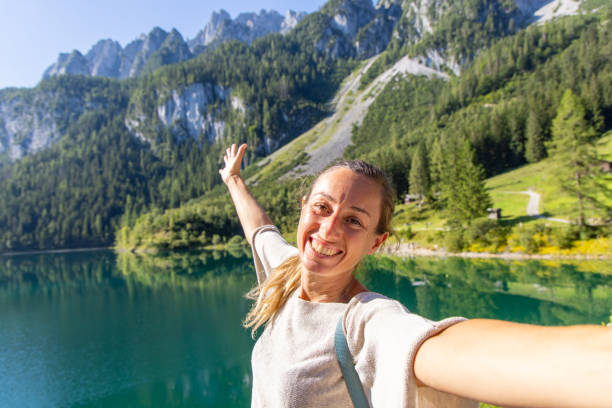 istock Excited Woman Taking a Selfie by a Pristine Mountain Lake 2168976204