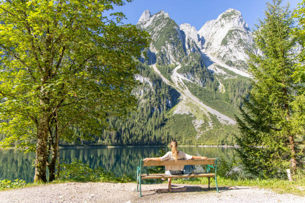 istock Woman Relaxing on Bench by Alpine Lake 2168976718