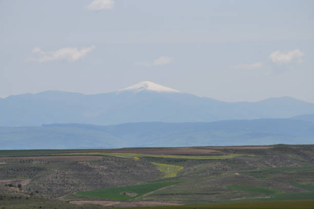 The centre of the photo shows San Lorenzo is the highest peak of La Rioja, an autonomous region of northern Spain mainly known because of the wines produced there. It's placed in the Sierra de la Demanda, which is a massif belonging to the wider Sistema Ibérico and placed south of the mid course of the Ebro River. \nGrisaleña is a municipality located in the province of Burgos, Castile and León, Spain. In the foreground are green fields