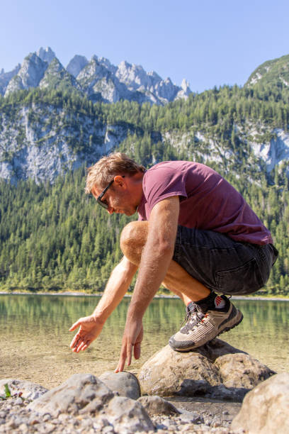 istock Man cupping fresh water from a Mountain Lake 2168979196