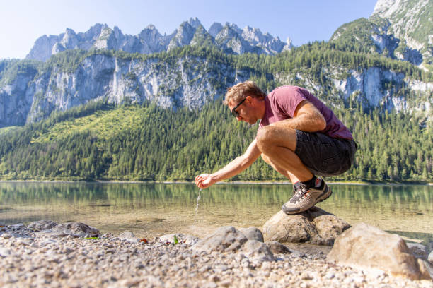 istock Man cupping fresh water from a Mountain Lake 2168979230