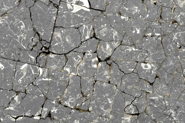 Broken cracked granite exterior block floor as abstract gray background close up
