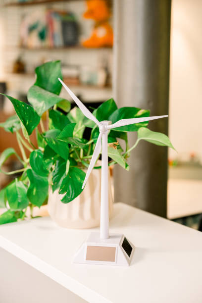 istock Miniature wind turbine model with potted plant in office setting 2168979658