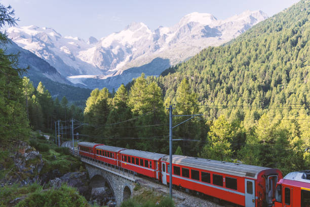 istock Red Train Crossing Bridge in Scenic Alpine Landscape 2168980062