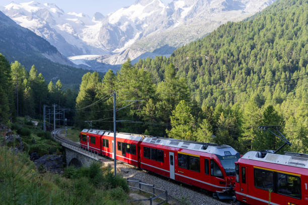 istock Red Train Passing Through Alpine Landscape with Snow-Capped Peaks 2168980168