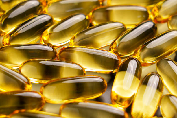 istock Yellow softgel translucent Omega 3 fatty acids capsules close up 2168980511