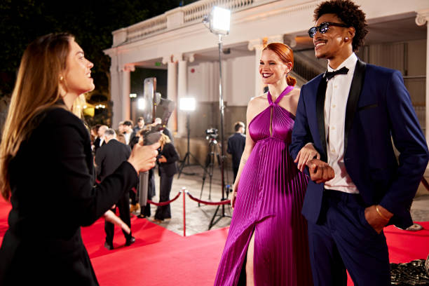 istock Vlogger interviewing celebrity couple at red carpet event 2168982513