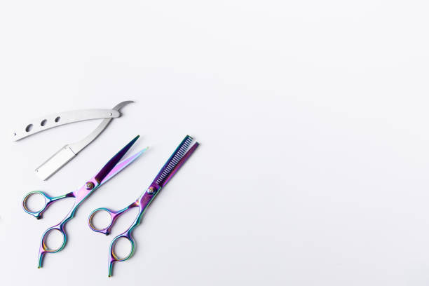 istock High-quality barbering tools featuring scissors and a razor, placed neatly in the lower-left corner on a pristine white background 2168982737