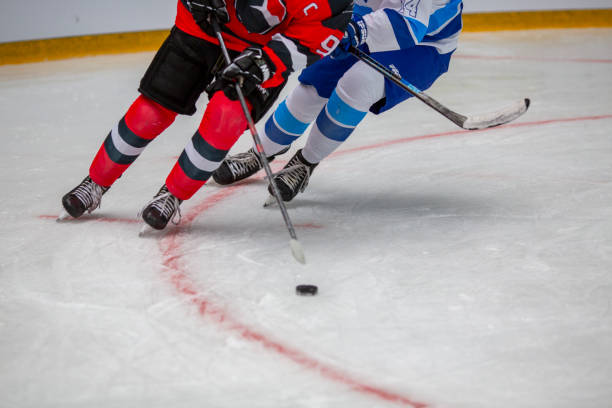 intense ice hockey battle for the puck - ijshockey mannen fotos stockfoto's en -beelden