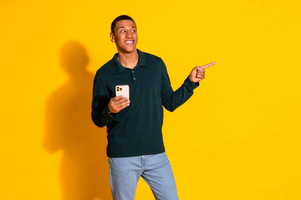 istock Photo of nice young man smart phone indicate finger empty space wear pullover isolated on bright yellow color background 2168983937