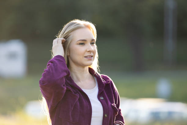 Happy beautiful blonde woman smiling while relaxing In park