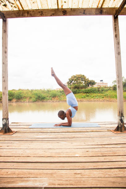 Person doing extreme hand standing, upside down. Silhouette. Doing handstand on egde of a viewpoint on a mountain, street workout, calisthenics