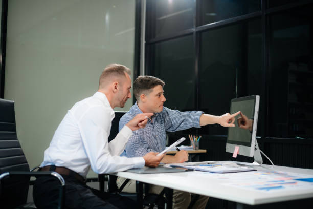istock Two business workers talking on the smartphone and using laptop 2168992194