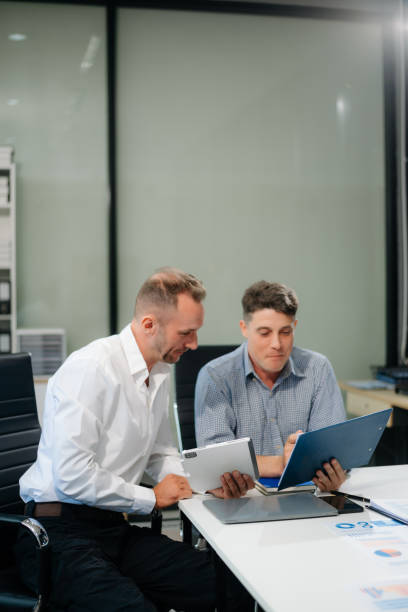 istock Two business workers talking on the smartphone and using laptop 2168992200