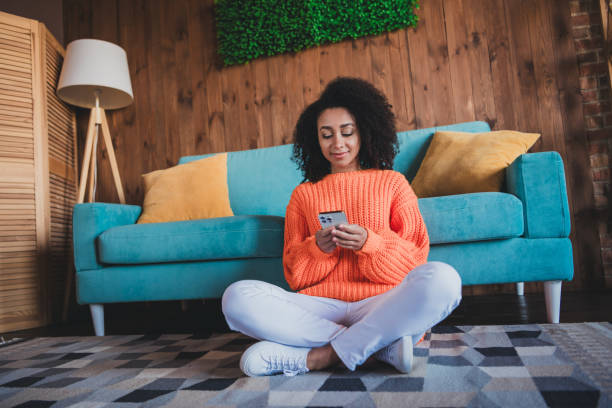 istock Photo of shiny cute girl dressed orange pullover staying home communicating modern device indoors house apartment room 2168995140