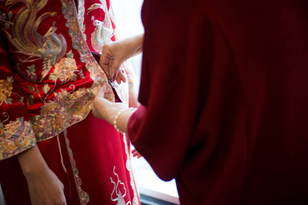 Tradition of the bride's mother helping her daughter put on the wedding dress