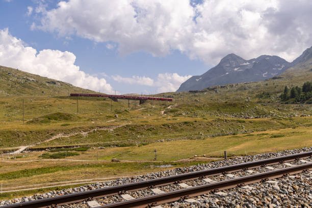 istock Train Crossing a Mountainous Landscape with Railway Tracks in Foreground 2169004268