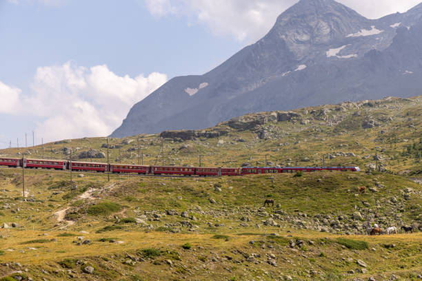 istock Red Train Crossing a Mountainous Bridge 2169004314