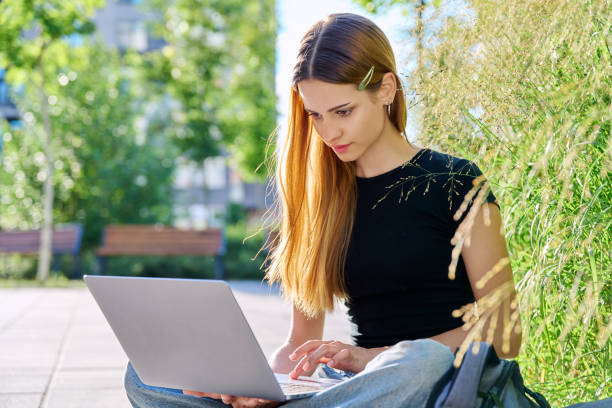 istock Young female college student typing on laptop computer outdoor 2169007783