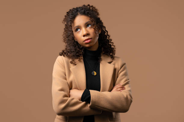 Bored upset african woman sighs, rolling eyes on beige. Teenager in displeasure Bored upset woman sighs and rolling eyes on beige background. 15 years old lady in displeasure, she is tired of situation, empty promises, talks. rolling eyes irritation displeased facial expression stock pictures, royalty-free photos & images