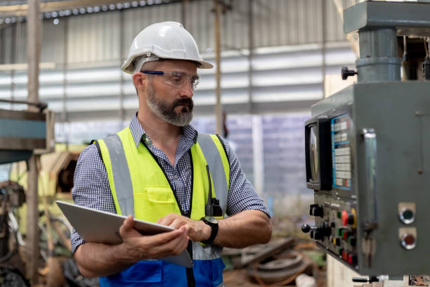 istock Industrial man engineer wear uniform and helmet using Tablet are checking system machine at factory. manager technician manufacturing. Workers industrial factory. 2169012329