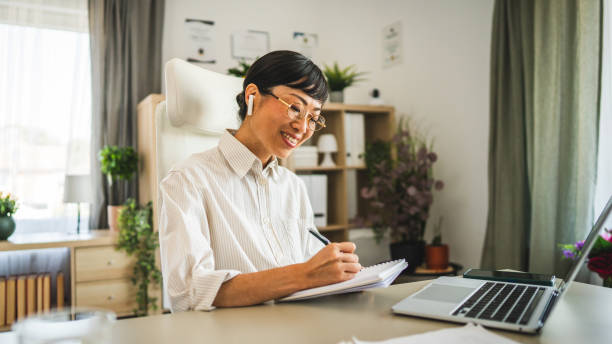 istock japanese woman with earphones work and write on notebook at office 2169020761