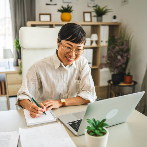 istock japanese woman with earphones work and write on notebook at office 2169020817