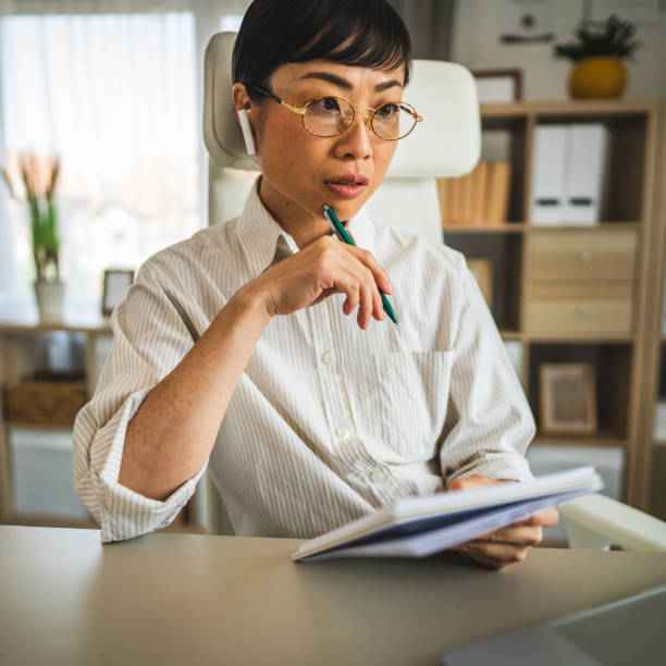 istock japanese woman with earphones work and write on notebook at office 2169022354