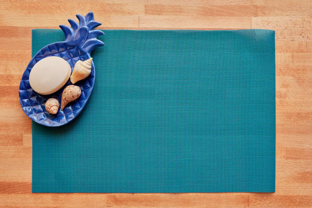 Spa-themed setup with seashells and soap on a blue mat with copy space