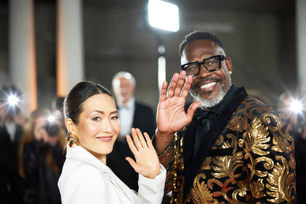 istock Smiling celebrities waving at paparazzi event 2169042984