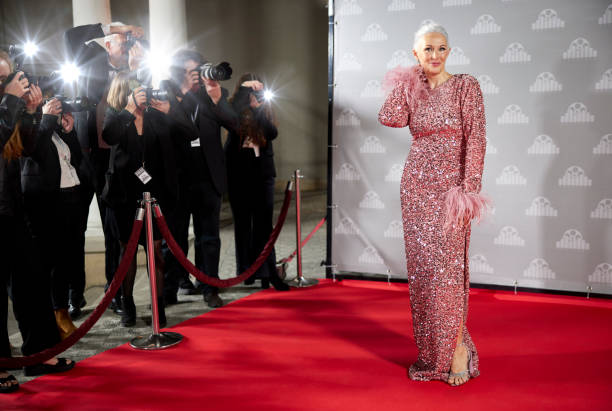 Female celebrity posing for paparazzi at event