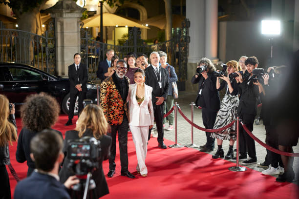 istock Smiling celebrities posing for paparazzi at event 2169043515