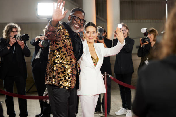 istock Happy celebrities waving at premier event 2169043864