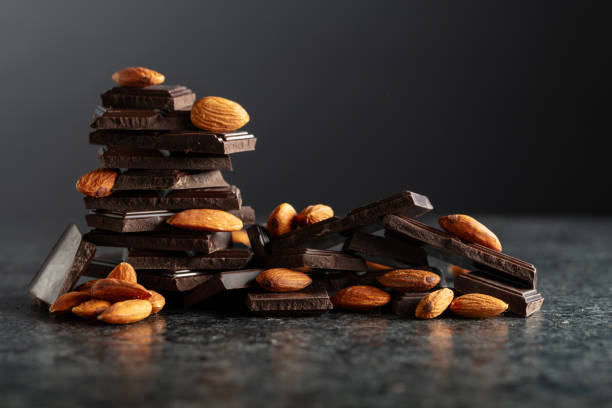 istock Broken dark chocolate bar with almond on a black background. 2169045206