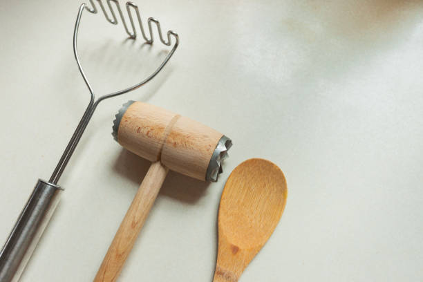 istock Kitchen utensils for mashing potatoes and meat tenderizer with wooden spoon 2169045286